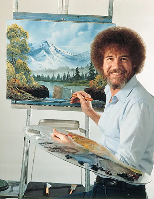 Bob Ross painting a landscape with mountains and trees